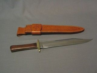 A reproduction Bowie knife with 10 1/2" blade and rosewood grip by R Middleton of Sheffield, contained in a carved leather case