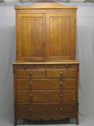 A Georgian Country oak cabinet on chest, the upper section fitted a cupboard enclosed by a panelled door, the base fitted 3 short drawers above 2 short and 3 long drawers, raised on bracket feet 49"