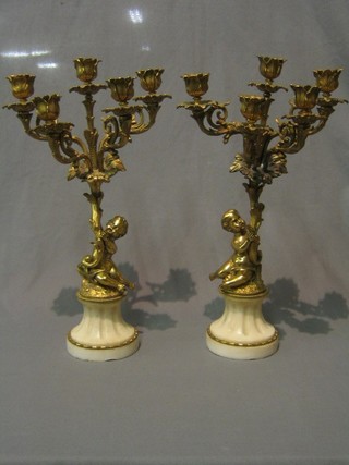 A pair of 20th Century gilt metal 5 light candelabrum supported by cherubs and raised on white marble bases (some damage to bases) 17"