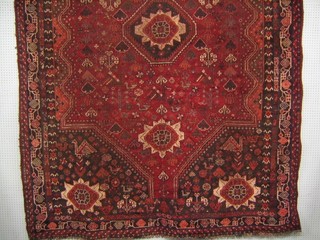 A contemporary red ground and floral patterned Shiraz rug 114" x 83"