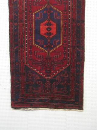 A contemporary red ground Persian Hamadan rug with diamond pattern to the centre within multi row borders 77" x 39"