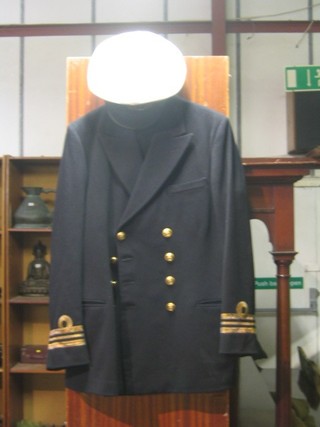 A Royal Navy Lieutenant commander's tunic and trousers by Bernard & Sons together with a Gieves & Hawkes peaked cap