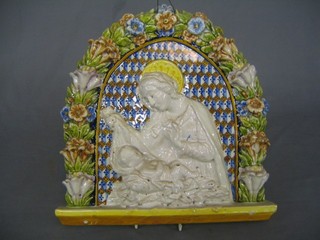 An Italian Majolica oval plaque depicting The Virgin Mary and The Christ Child, contained in an arch 14"