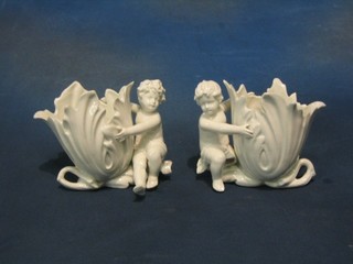 A pair of 19th Century blanc de chine porcelain chassepot in the form of flower heads supported by cherubs 5" (some light chipping)