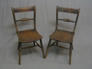 A pair of 19th Century elm bar back Windsor chairs with turned mid rails, raised on turned supports united by an H framed stretcher