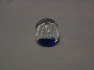 A blue glass paperweight with burst decoration