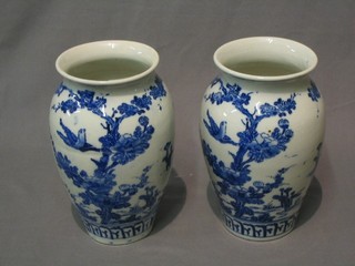 A pair of Oriental blue and white vases decorated birds amidst branches 9"