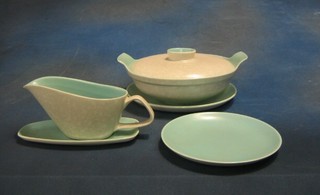A 20 piece Poole Pottery green glazed dinner service comprising 2 circular twin handled tureens 9", 4 dinner plates 10", 7 side plates 9" and 6 tea plates, sauce boat and stand