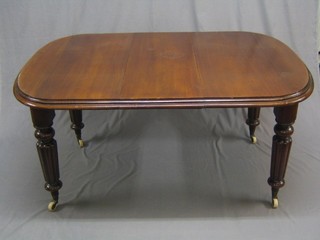 A Victorian oak extending dining table raised on turned and reeded supports