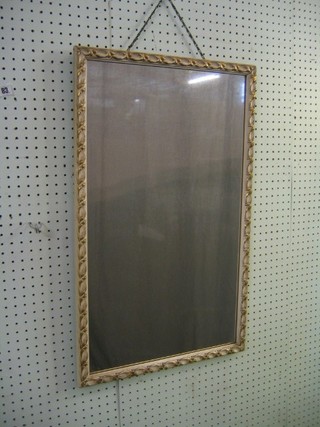 A rectangular plate mirror contained in a decorative white and gilt frame 29"