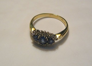 A lady's 18ct gold dress ring set 3 oval cut sapphires supported by diamonds