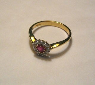 A lady's 18ct gold dress ring set a heart cut ruby, surrounded by diamonds