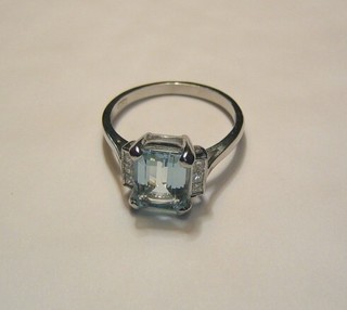 A lady's attractive 18ct white gold dress ring set a rectangular cut aquamarine supported by 6 diamonds