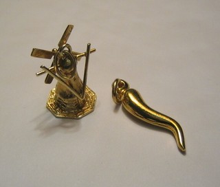 A "gold" charm in the form of a windmill and 1 other