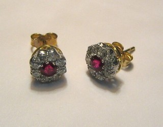 A pair of lady's ear studs, each set a ruby surrounded by diamonds (approx 0.72ct)
