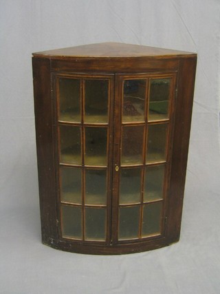 A Georgian mahogany bow front hanging corner cabinet, the shelved interior enclosed by astragal glazed panelled doors, 27"