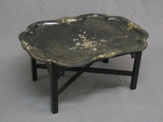 A 19th Century oval lacquered tray with bracketed border and inlaid mother of pearl decoration, fixed to an associated Oriental base with X framed stretcher and square supports (4 visible screws to each corner and large chip to top right hand corner) 30"