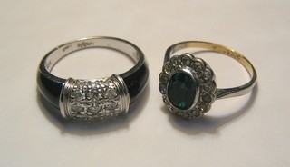 A lady's gold dress ring set a green stone surrounded by white stones and 1 other dress ring