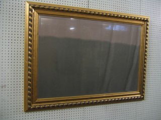 A rectangular bevelled plate wall mirror contained in a decorative gilt frame 43"