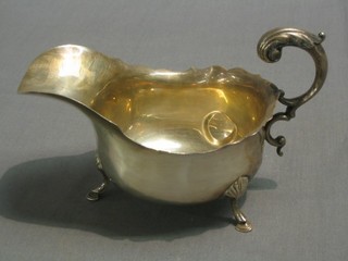 A silver sauce boat with C scroll handle, raised on 4 hoof supports, Birmingham 1926 (some dents), 3 ozs