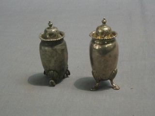 A pair of circular silver pepper pots marked Chester