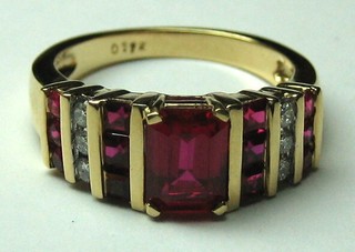 A lady's 18ct gold dress ring set 6 diamonds and supported by simulated rubies