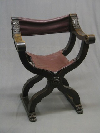 A 19th/20th Century carved oak X framed folding open arm chair