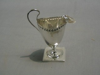 A Victorian silver cream jug raised on a square foot, Birmingham 1893, 3 ozs