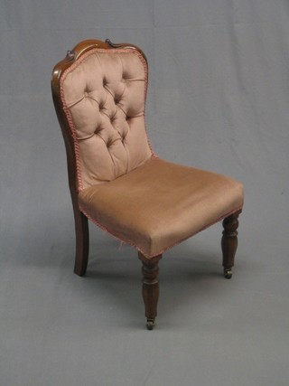 A Victorian mahogany show frame nursing chair raised on turned supports upholstered in pink buttoned Dralon