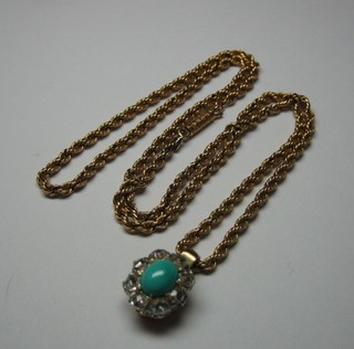 A gold pendant set an oval cabouchon cut turquoise surrounded by 8 diamonds and hung on a 15ct gold chain