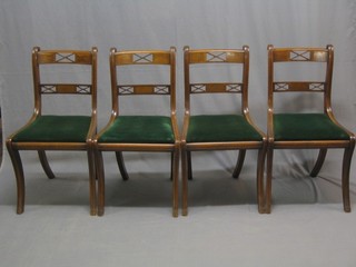 A set of 8 Regency style mahogany bar back dining chairs with upholstered drop in seats raised on front and rear sabre supports