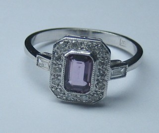 A lady's 18ct white gold dress ring set a rectangular pink sapphire supported by diamonds and 2 baguette cut diamonds to the shoulders