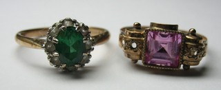 A lady's gold dress ring set a  green stone supported by white stones and 1 other gold dress ring