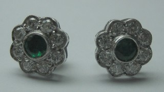 A pair of 18ct white gold ear studs set emeralds surrounded by 9 diamonds (approx 0.50ct)
