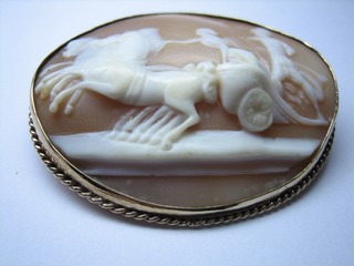 A lady's oval shell carved cameo brooch decorated a Charioteer contained in a gold brooch mount