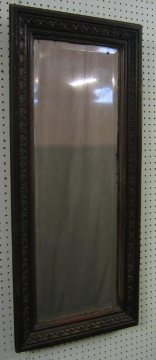 A Victorian rectangular bevelled plate wall mirror contained in a carved oak frame 34" x 15"