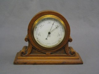 An Edwardian table barometer and thermometer with porcelain dial contained in an oak case