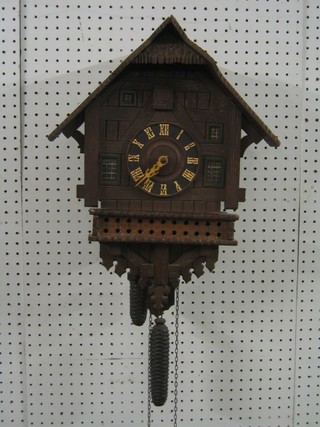 A 19th/20th Century carved Swiss cuckoo clock in the form of a house complete with weights and pendulum