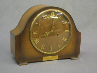 A 1950's striking mantel clock with gilt Roman numerals contained in an arch shaped walnut case