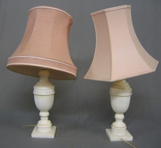 A pair of white marble finished table lamps with pink shades