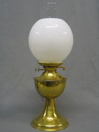 A 20th Century brass oil lamp with clear glass chimney and white glass shade