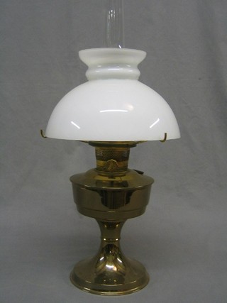 A  20th Century brass oil lamp reservoir with white glass shade (f and r) and with clear glass chimney