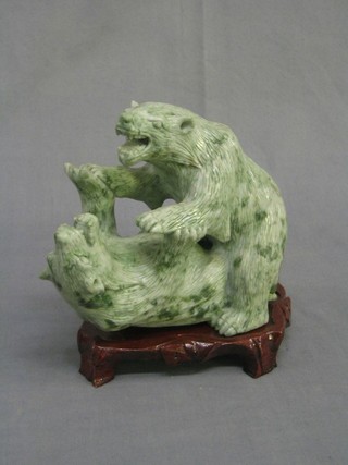 A jade coloured hard stone figure of 2 fighting Polar bears 6" raised on a hardwood stand