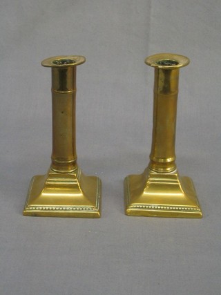 A pair of 19th Century brass candlesticks, raised on square bases complete with ejectors 6"