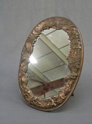 An oval plate easel mirror contained in an embossed metal frame 13"