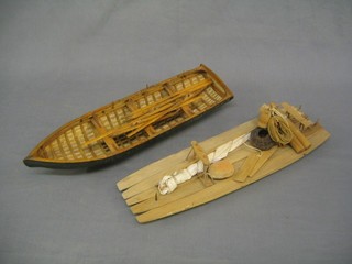 A wooden model of a Dow 16" and a model of a rowing boat 16"