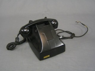 A field telephone in a black Bakelite case the bottom marked N2124A20T