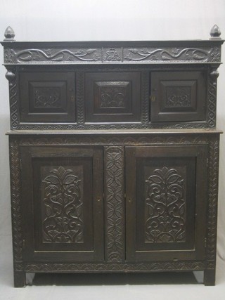 An 18th/19th Century  carved oak tridarn (now in 2 sections as a court cupboard) the upper section fitted cupboards enclosed by panelled doors, the base fitted a double cupboard enclosed by panelled doors, marked TSA 1626, 55"