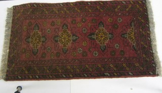 A contemporary Afghan slip rug decorated medallions to the centre 36" x 21"