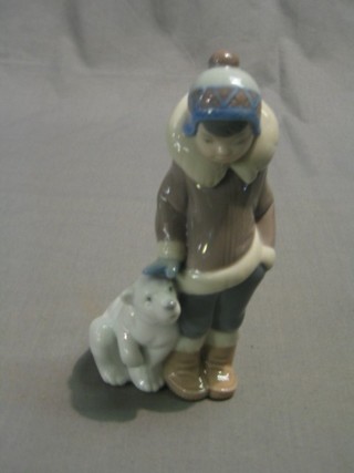 A Lladro figure of a standing Eskimo boy with baby polar bear 6"